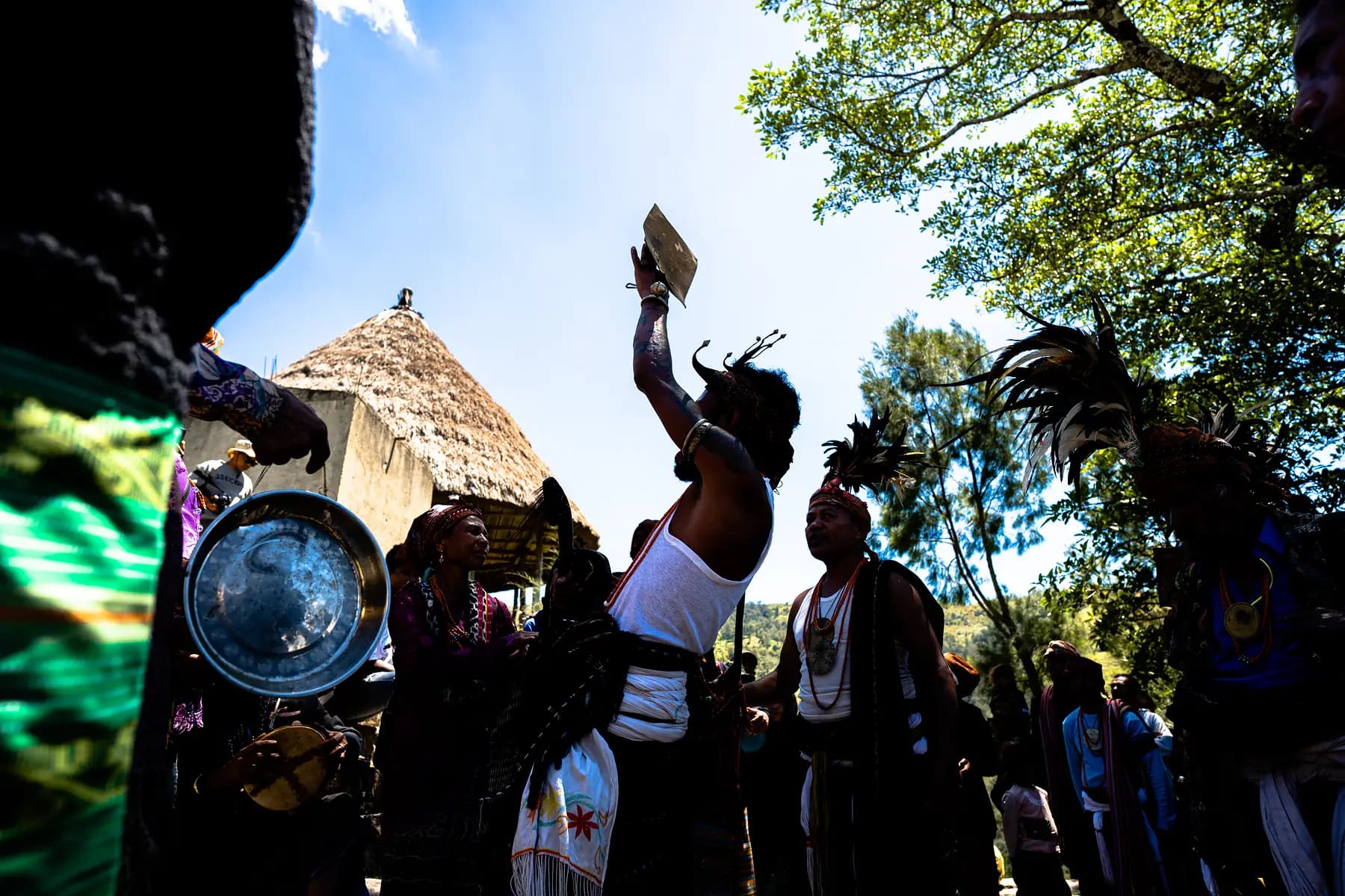 An elder raises an offering; the ceremony begins