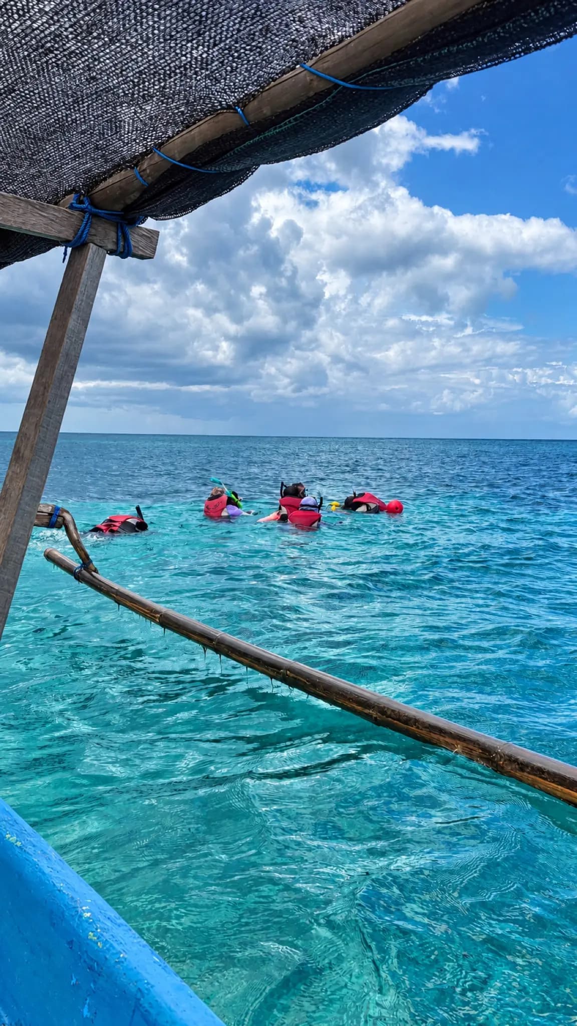 Snorkellers off an outrigger, Atauro