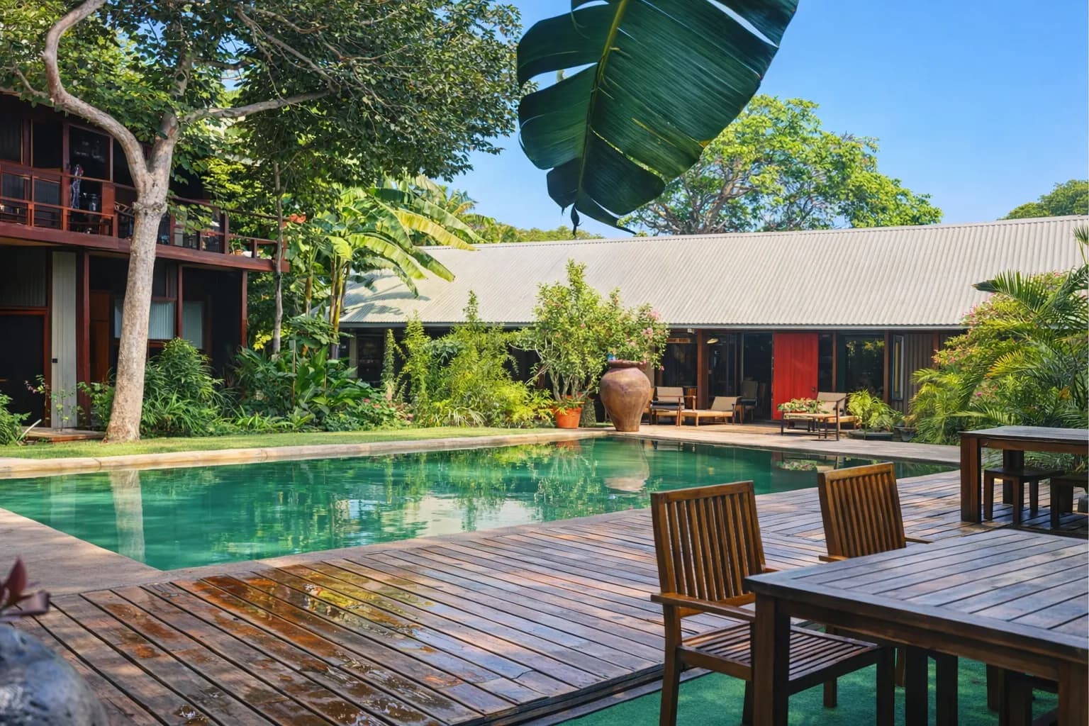 Pool area with banana palms and lush tropical gardens at Hotel Esplanada