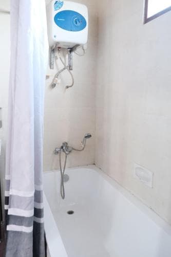 Arbiru Beach Resort bathroom with bathtub, overhead water heater and shower