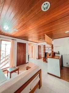 Arbiru Beach Resort suite living area with wood-panelled ceiling and modern furnishings