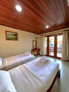 Arbiru Beach Resort suite with king and twin beds under wood ceiling