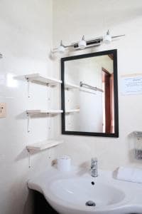 Arbiru Beach Resort bathroom with mirror, shelving and pedestal sink