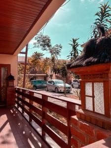 Arbiru Beach Resort balcony view of garden and parked cars at golden hour