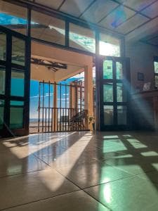 Arbiru Beach Resort lobby entrance with sun rays through arched windows