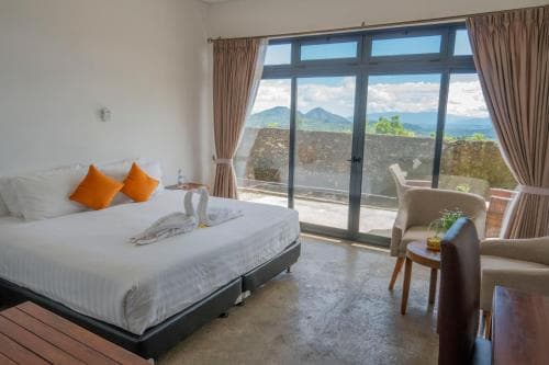 Balibo Fort Hotel bedroom with king bed and mountain view through patio doors