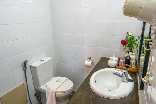 Balibo Fort Hotel compact bathroom with toilet, vanity and timber accents