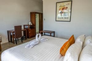 Balibo Fort Hotel bedroom with framed map artwork above a king bed
