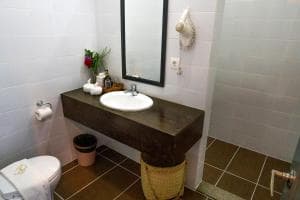 Balibo Fort Hotel bathroom with concrete vanity, mirror and tile floor