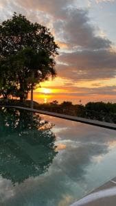 Balibo Fort Hotel infinity pool reflecting golden sunset over the hills