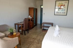 Balibo Fort Hotel suite living area with seating, work desk and framed art