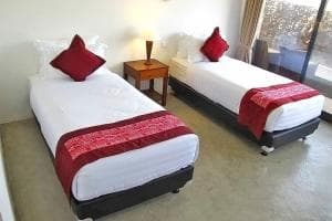 Balibo Fort Hotel twin-bed room with red accent throws and pillows