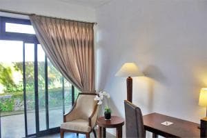 Balibo Fort Hotel work corner with armchair, lamp and curtained window