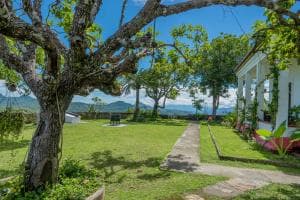 Balibo Fort Hotel garden walkway with shade tree and distant sea view