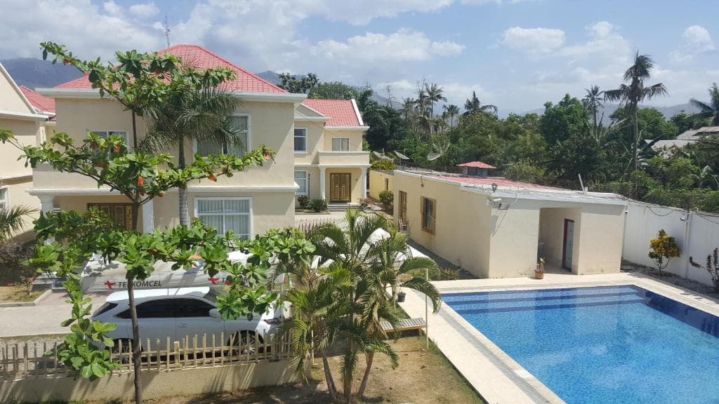 Beach Garden Hotel pool surrounded by white villas, palms and tropical garden