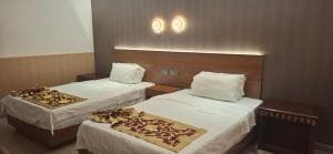 Beach Garden Hotel twin-bed room with patterned bed runners and circular wall lights