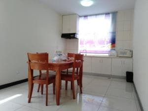 Beach Garden Hotel apartment dining nook with kitchenette and timber chairs