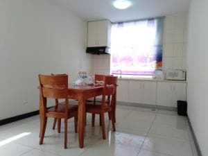 Beach Garden Hotel apartment dining area with kitchenette and timber chairs