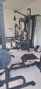 Beach Garden Hotel weight room with squat rack, bench and dumbbells