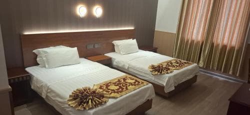 Beach Garden Hotel Twin Room with patterned bed runners and circular wall lights