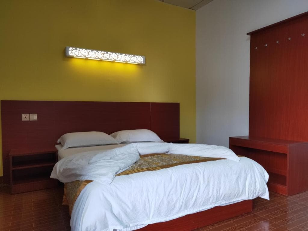 Chong Ti Hotel modern bedroom with yellow accent wall and king bed