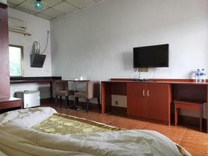 Chong Ti Hotel bedroom with TV cabinet, work desk and tile floors