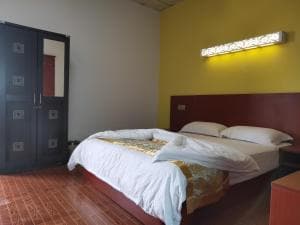 Chong Ti Hotel deluxe queen room with yellow feature wall and dark wardrobe