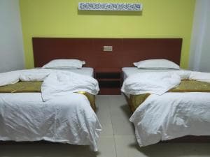 Chong Ti Hotel twin room with white linens and yellow accent wall