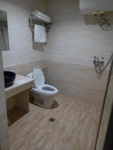 Chong Ti Hotel bathroom with toilet, vessel basin and tiled floor