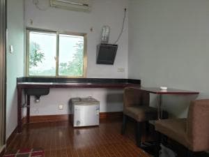 Chong Ti Hotel work desk and tan armchairs by window with garden view
