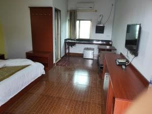 Chong Ti Hotel bedroom with wall-mounted TV, work desk and aircon