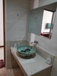 Chong Ti Hotel vanity with green glass vessel basin and large mirror