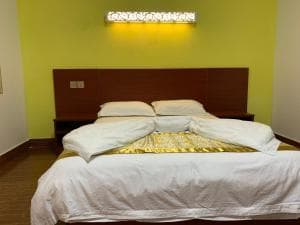 Chong Ti Hotel king bed with yellow accent wall and warm lighting