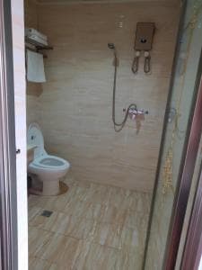 Chong Ti Hotel bathroom with toilet and hand-held shower fixture