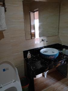 Chong Ti Hotel vanity with blue vessel basin on dark marble counter