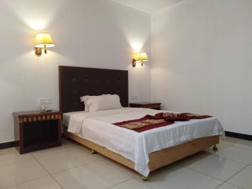 Excelsior Resort suite with king bed and warm bedside lighting