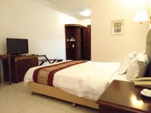 Excelsior Resort room with king bed, wardrobe and TV cabinet