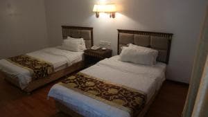 Excelsior Resort twin-bed room with brocade-pattern bed runners