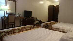 Excelsior Resort family suite with two beds, work desk and TV