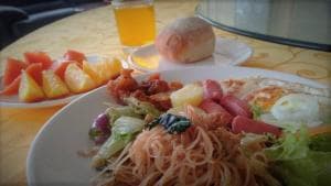 Excelsior Resort plated breakfast with noodles, fried egg, and fresh fruit