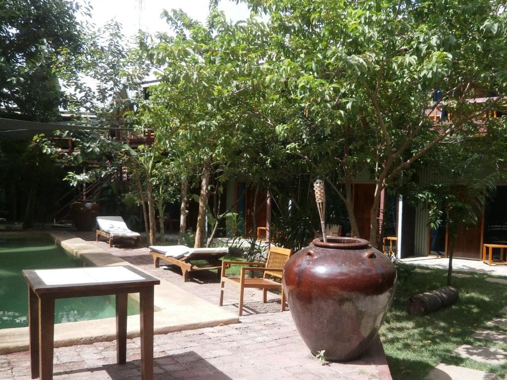 Hotel Esplanada garden courtyard with large terracotta urn, sun loungers and shaded trees