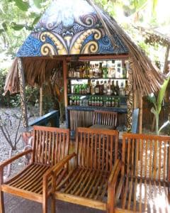Hotel Esplanada tropical pool bar with carved Timorese roof and wooden chairs