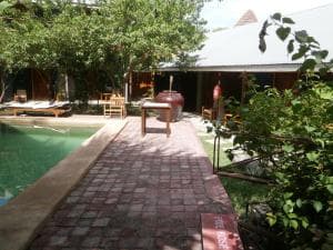 Hotel Esplanada pool deck with paved walkway, BBQ and lush garden