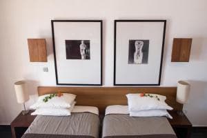Hotel Esplanada twin beds with framed prints — signature minimalist style