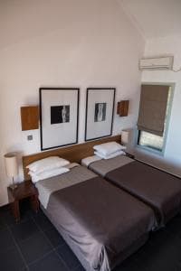 Hotel Esplanada twin beds with framed prints under a high vaulted ceiling