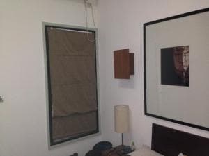 Hotel Esplanada room interior with shuttered window, framed artwork and side table