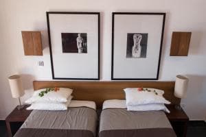 Hotel Esplanada twin beds turned down with welcome flowers and framed prints