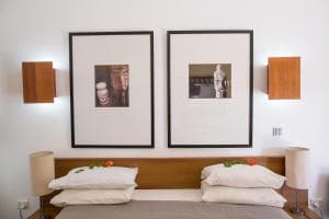 Hotel Esplanada twin beds with framed prints and bedside reading lamps