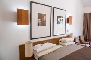 Hotel Esplanada bedroom with framed art, bedside lamp and seating area