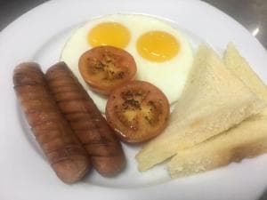 Hotel The Ramelau breakfast plate with sausages, eggs, grilled tomato and toast